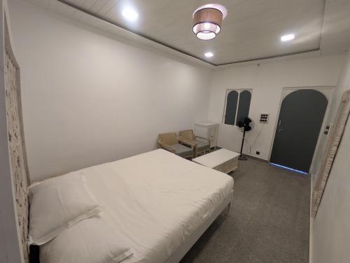 a white room with a bed and a desk at Nomada in Mount Ābu
