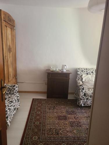 a room with a table and a chair and a rug at B&B Ma Maison in Govone