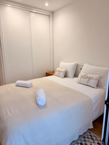 two beds with towels on top of them in a room at Alojamento Xaandar Beach Spot in Nazaré
