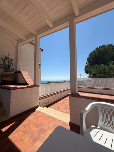a porch with a white chair on a patio at Il Villotto in Monte SantʼAngelo