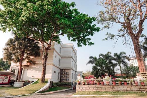 a house with trees and flowers in front of it at Nigara Residency in Vandanmedu