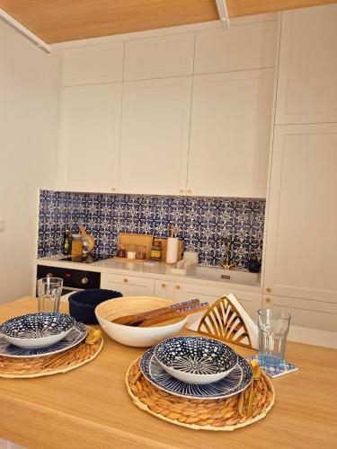 a kitchen with a wooden table with plates on it at Sea Colours Apartment Budva in Budva