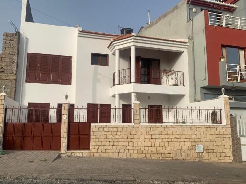 a white house with a fence in front of it at Alana's loft in Praia