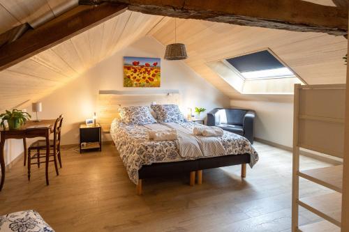 a bedroom with a bed and a desk in a attic at Chambres d'hôtes, table d'hôtes des Reinières proche La Loire à Vélo, 3 chambres 7 couchages in Le Fossé-Neuf