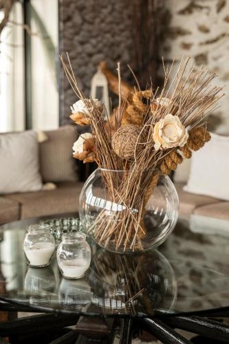 a glass vase with flowers on a glass table at Panorama Prespes in Agios Germanos