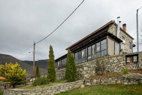a stone house with a stone wall at Panorama Prespes in Agios Germanos