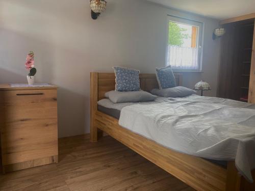 a bedroom with a bed with a dresser and a window at Domki na Wyspie in Gdańsk