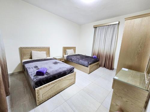 a room with two beds and a window at Afnan Cairo Airport in Cairo