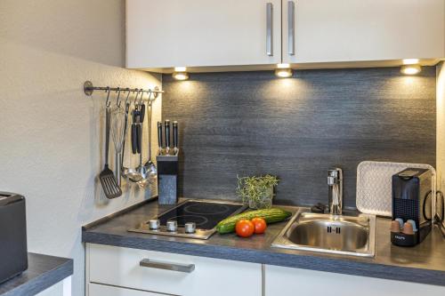 a kitchen with a sink and vegetables on the counter at Pier17 Appartement 5 in Borkum