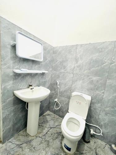 a bathroom with a white toilet and a sink at Just Inn in Puttalam
