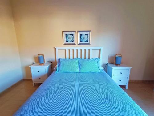 a bedroom with a bed with blue sheets and two night stands at Miramar 8 - San Sebastin de La Gomera in San Sebastián de la Gomera