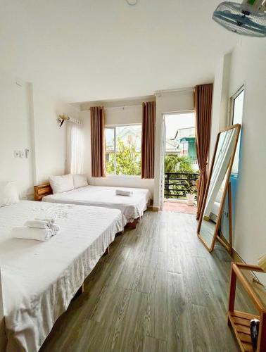Cồn Giả ViênにあるThảnh Thơi HomeStay & Yogaのベッドが2つと大きな窓がある寝室