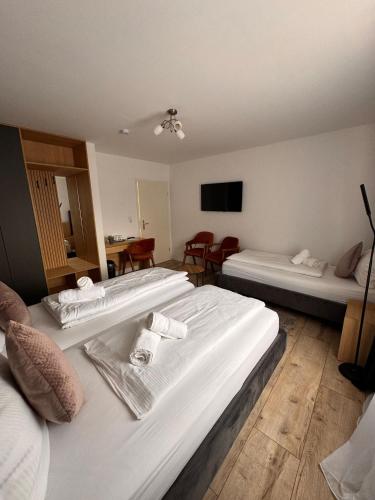 a hotel room with two beds and a tv at Grand Hotel in Soltau