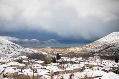 a town covered in snow with mountains in the background at Panorama Prespes in Agios Germanos
