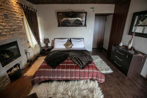 a bedroom with a large bed and a fireplace at Panorama Prespes in Agios Germanos