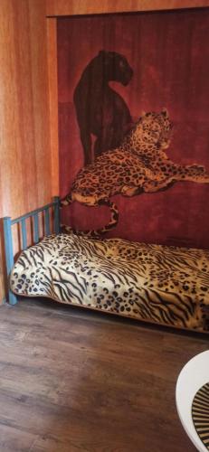 a bed with a leopard painting on the wall at Agroturystyka Stajnia Dorado Pokoje Gościnne i Apartamenty in Leoncin