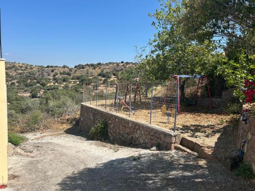 a park with a playground on the side of a hill at Petrino view at vafios in Vafiós