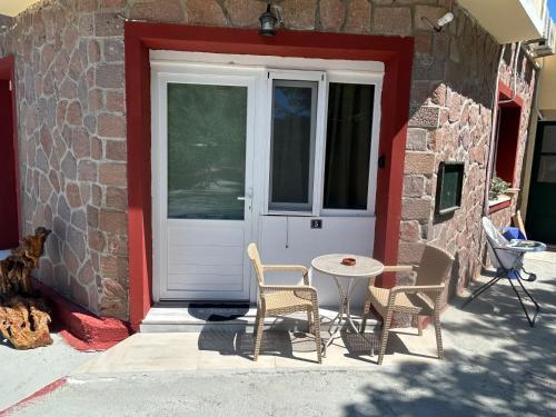 a door with two chairs and a table in front of it at Petrino view at vafios in Vafiós