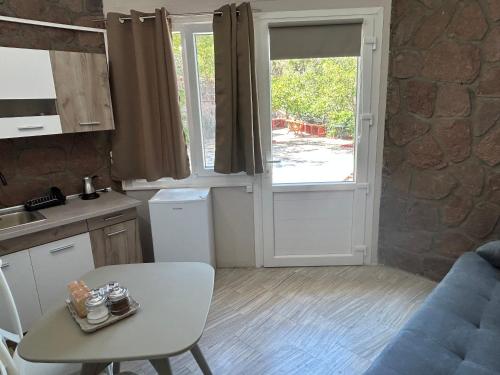 a small kitchen with a table and a door to a yard at Petrino view at vafios in Vafiós