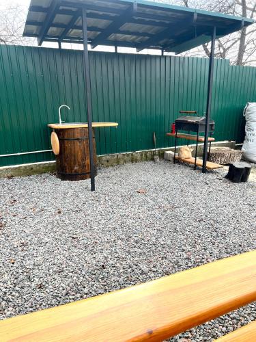 a wooden bath tub sitting under a green building at Гостевой дом Фестивальный in Kyiv