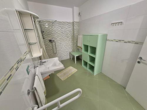 a bathroom with a sink and a green cabinet at Monolocale Santa Caterina in Santa Caterina di Nardò