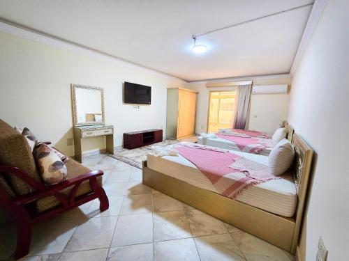 a bedroom with two beds and a television in it at Afnan Cairo Airport in Cairo