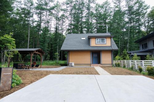 a small house with a porch and a white fence at lamp yamanaka-山中湖 河口湖 プライベートヴィラ-132平米-最大10名-BBQ無料-乳幼児可-長期滞在設備充実-山中湖車5分-河口湖車20分 in Yamanakako