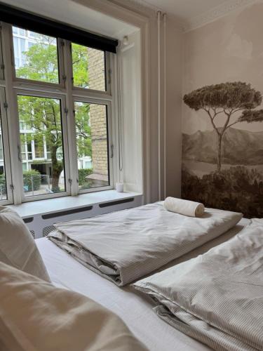 a bedroom with two beds and a window at Stylish Apartment with Rooftop in Trendy Vesterbro in Copenhagen
