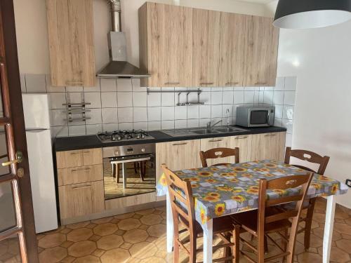 a kitchen with a table and a kitchen with a stove at Agriturismo Il Giglio di Sant' Antonio in Montemassi