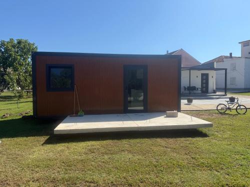 a small house in the middle of a yard at Mobilna kucica M in Donji Štoj