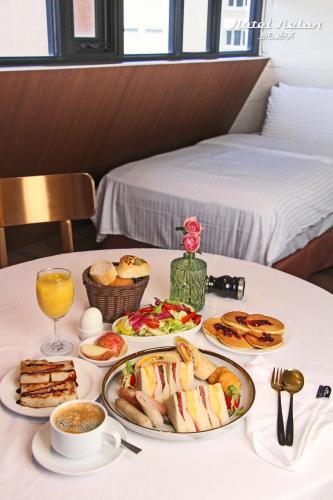 a table with several plates of food on it at Hotel Relax 5 in Taipei