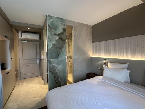 a bedroom with a large bed with a marble wall at James Vignoble Hôtel, Eguisheim in Eguisheim