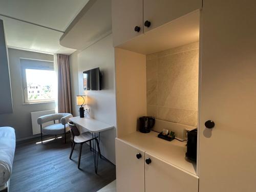 a hotel room with a bed and a desk and a table at James Vignoble Hôtel, Eguisheim in Eguisheim