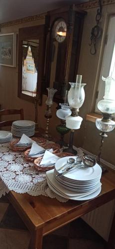 a table with plates and dishes on top of it at Agroturystyka Stajnia Dorado Pokoje Gościnne i Apartamenty in Leoncin