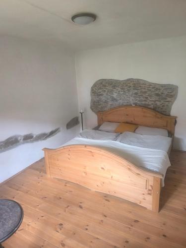 a wooden bed in a room with a wooden floor at Ubytování u řeky Lužnice na statku ,,U stříbrné podkovy" in Třebiště