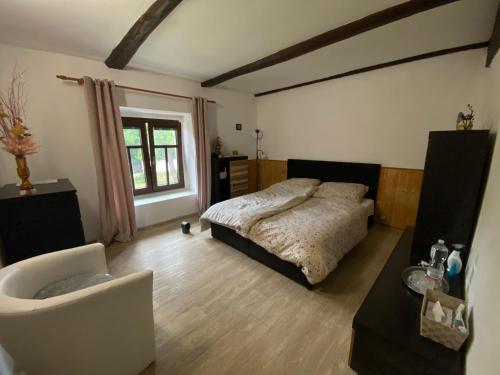a bedroom with a bed and a chair and a window at Underhillhouse in Liběšice