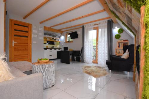 a living room with a person sitting in a chair at Lux Houses w DOMKU tylko DWA APARTAMENTYz jacuzzi zewnętrznym in Groń