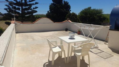 a table and two chairs on a patio at Villa Porto fossa 2 in Marzamemi