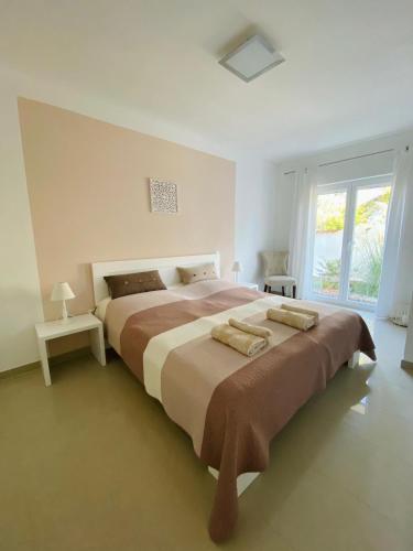 a bedroom with a large bed with two pillows on it at Apartmani PERLA 55 in Poreč