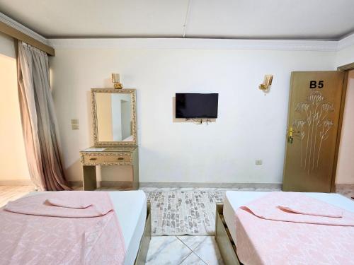 a bedroom with two beds and a mirror at Afnan Cairo Airport in Cairo