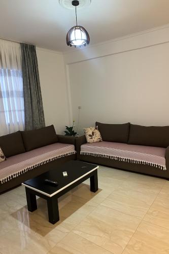 a living room with two couches and a coffee table at Villa Nava Ksamil in Polisi i Vogël