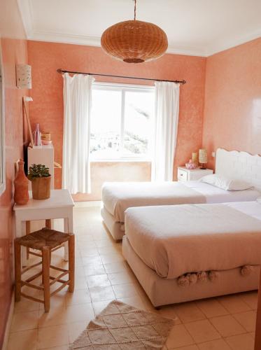 a bedroom with two beds and a window at Blue Kaouki Boutique Hotel in Sidi Kaouki
