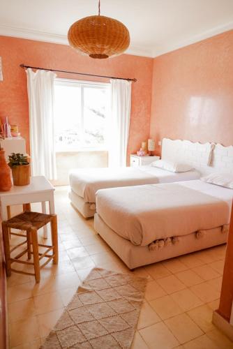 two beds in a bedroom with a large window at Blue Kaouki Boutique Hotel in Sidi Kaouki