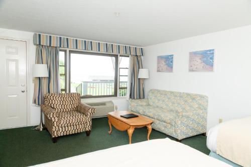 a hotel room with a bed and a couch and a chair at Terrace By The Sea in Ogunquit