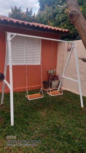 a porch swing with two potted plants on it at Casa Assumpção, centro in Brotas