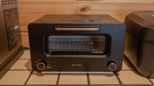 a black toaster oven sitting on top of a counter at lamp yamanaka-山中湖 河口湖 プライベートヴィラ-132平米-最大10名-BBQ無料-乳幼児可-長期滞在設備充実-山中湖車5分-河口湖車20分 in Yamanakako