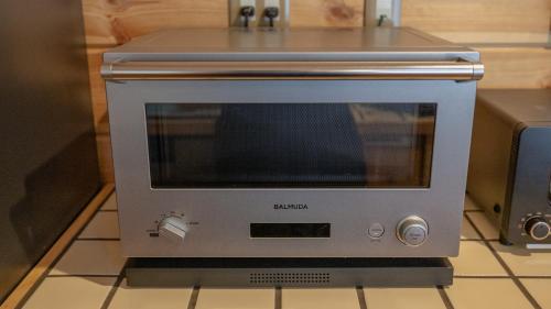 a silver toaster oven sitting on a kitchen counter at lamp yamanaka-山中湖 河口湖 プライベートヴィラ-132平米-最大10名-BBQ無料-乳幼児可-長期滞在設備充実-山中湖車5分-河口湖車20分 in Yamanakako