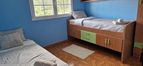 a bedroom with two twin beds and a window at El Rincón Del Silencio in Moucide