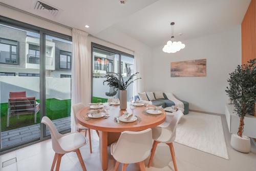 a dining room with a table and white chairs at EasyGo- Lavish Townhouse with facilities in Dubai