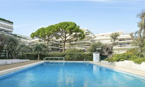 a swimming pool in front of a large building at Mas du Tanit - Escapade en bord de mer, terrasse & soleil in Antibes